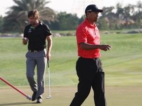 Tiger Woods (R) of the U.S. and Robert Rock of England walk on the 17th green during the final round of the Abu Dhabi Championship at the Abu Dhabi Golf Club January 29, 2012. Rock won his head-to-head duel with a ragged Woods to lift the Abu Dhabi Championship title on Sunday after the former world number one produced his worst performance of the week. REUTERS/Nikhil Monteiro
