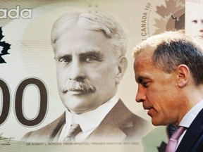 Mark Carney, governor of the Bank of Canada and chairman of the Financial Stability Board, walks past a replication of the new Canadian 100 dollar bill made of polymer in Toronto November 14, 2011. (REUTERS/Mark Blinch)