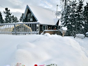 Flowers rest in a snowbank at the scene of five deaths in the Porter Creek area of Whitehorse, Yukon, on Monday, Jan 30, 2012. The cause of the deaths is still under investigation, but police say that foul play is not suspected at this time. Ian Stewart/Yukon News