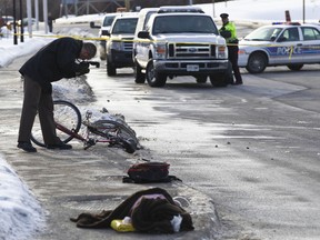 Investigators at the scene of a serious accident involving a cyclist and a car on Carling Avenue near Archibald Street in Ottawa on Thursday Feb. 2,2012. 
(ERROL MCGIHON/OTTAWA SUN)