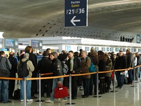 Passengers stand in a queue in a terminal at the Charles-de-Gaulle airport in Roissy, near Paris, December 20, 2011. REUTERS/Benoit Tessier