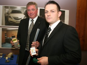 William Crate, left, director of security and intelligence for the Canadian Bankers Association and lead investigator Dwayne Perron hold electronic devices used in an alleged debit card skimming ring. (Terry Davidson/Toronto Sun)