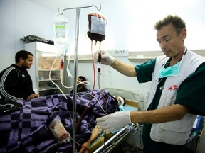 A doctor from Doctors Without Borders, or Medecins Sans Frontieres, prepares a blood transfusion for a wounded rebel fighter in the Libyan town of Zintan near the Western Mountain region, 150 km southwest of the capital Tripoli, May 11, 2011. (REUTERS/Zohra Bensemra)
