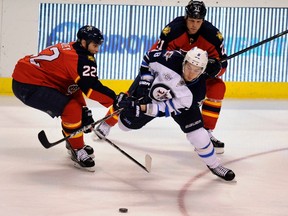 Florida Panthers' Matt Bradley (L) and Krystofer Barch defend against Winnipeg Jets' Alexander Burmistrov (C) during the third period of their NHL hockey game in Sunrise, Florida February 3, 2012.