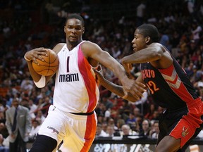 Miami Heats' Chris Bosh moves around Toronto Raptors' Ed Davis during their NBA game in Miami, Sunday. (REUTERS)