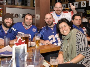 These fans are all smiles while watching the Super Bowl at Local Heroes on Merivale Rd. on Sunday. (Matthew Usherwood/Ottawa Sun)