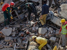 Rescue workers go through the rubble of a three-storey factory, which collapsed in Lahore on February 6, 2012. (REUTERS/Mohsin Raza)