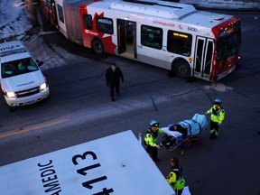 Paramedics transport a passenger to hospital after two buses collided on the Transitway near Tunney's Pasture during afternoon rush hour Tuesday, Feb. 7, 2012. (Darren Brown/Ottawa Sun)
