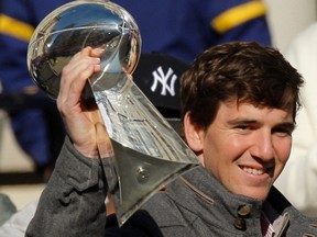 New York Giants quarterback Eli Manning holds up the Vince Lombardi Trophy as he attends a ceremony in honor of the Giants' win in the NFL Super Bowl XLVI, at City Hall Plaza in New York. February 7, 2012. (REUTERS/Eduardo Munoz)