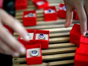 An employee packages replicas of the British royal engagement ring at a jewellery factory in Yiwu, Zhejiang province January 12, 2011.   REUTERS/Carlos Barria)