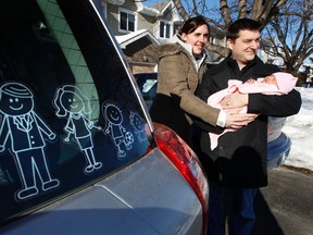 Kent Mannen poses for a photo with his wife Meghan and his three week old baby Abby outside their Barrhaven house in Ottawa Feb 8, 2012. Barrhaven is one of the fastest growing neighborhoods in Ottawa. (Tony Caldwell/Ottawa Sun)
