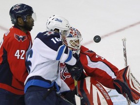 Capitals goalie Tomas Vokoun (R) watches the puck fly past during an attempt on goal by Jets captain Andrew Ladd as Capitals Joel Ward watches on Thursday night. (JASON REED/Reuters)