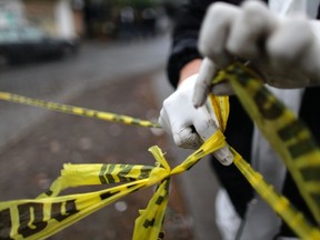 A forensic technician ties a used police line together to seal off a crime scene in Monterrey February 8, 2012. (REUTERS/Daniel Becerril)
