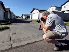 A photographer takes a picture of a blood stain left in an alley near 157 Avenue and 45 Street, July 24, 2011. DAVID BLOOM EDMONTON SUN FILE PHOTO