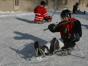 Ottawa sledge hockey player Ben Delaney takes some shots on net Saturday afternoon during an exhibition of the sport on the Rideau Canal as part of Hockey Day in Canada. Hundreds took the chance to strap in and try the sport themselves. DOUG HEMPSTEAD/Ottawa Sun