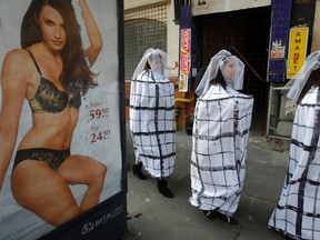 Girls dressed as brides in cages march during a promotional event for the movie "Daca Bobul nu moare" ("If the Seed doesn't die") directed by Sinisa Dragin and to draw attention to the dangers of human trafficking and sexual exploitation, in central Bucharest November 19, 2011.(REUTERS)
