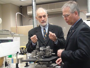 Carleton University Prof. Jacques Albert shows minister of state for science and technology Gary Goodyear some of the technology in his lab. Albert was awarded a $599,000 grant Monday. MARLO CAMERON/OTTAWA SUN