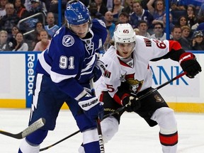 Tampa sniper Steve Stamkos (left), shown battling Sens defenceman Erik Karlsson for the puck Tuesday night, has nothing but praise for Daniel Alfredsson. (Mike Carlson/Reuters)