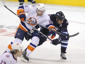 Jets defenceman Dustin Byfuglien battles Islanders winger Josh Bailey Tuesday. Once again the Jets’ lack of scoring cost the team a chance at a win. (JASON HALSTEAD/Winnipeg Sun)