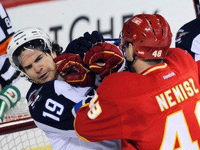 Jets’ Jim Slater (L) gets pushed by Flames’ Greg Nemisz during Winnipeg’s 5-3 loss on Friday.