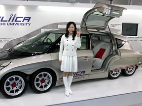 A Japanese woman poses in front of a prototype eight-wheel drive electric vehicle "Eliica." (FILE PHOTO)
