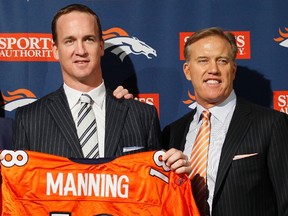 New Broncos quarterback Peyton Manning (left) holds his jersey with vice-president John Elway in Englewood, Colo., on Tuesday, March 20, 2012. (Rick Wilking/Reuters)