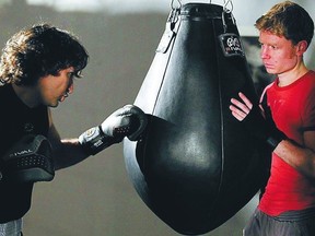 The Ottawa Sun's Anthiny Furey, right, holds the punching bag for MP Justin Trudeau as he trains for this weekend's charity fight.