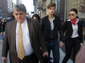 Oliver Karafa, 19 (middle) walks out of College Park court with his lawyer and sister Edita after receiving bail. (Jack Boland/Toronto Sun)