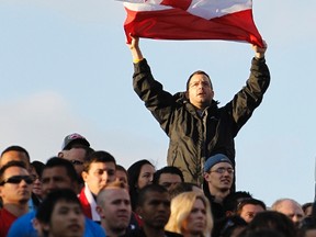A Canada fan waves the Canadian flag as the national anthem is played before their CONCACAF Olympic qualifying soccer match against the United States in Nashville, Tennessee March 24, 2012. (REUTERS/Harrison McClary)