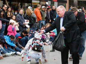 Mayor Rob Ford throws chocolate eggs to kids at the Beaches Easter Parade on Sunday.
(CRAIG ROBERTSON, Toronto Sun)
