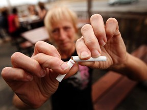 Darlene Bond, a server at Jonny Canuck's Bar Grill in Orleans, breaks a cigarette on their patio Thursday, March 22, 2012. A city-wide outdoor smoking ban affecting patios began April 2, 2012. (DARREN BROWN/QMI AGENCY)
