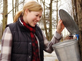 Angela Coleman of Cornwall, Ont., checks out one of the taps at Sand Road Maple Farm, the operation she owns with her husband. (CHERYL BRINK//QMI AGENCY)