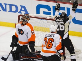 Pittsburgh Penguins' Steve Sullivan (26) celebrates a goal against Philadelphia Flyers goalie Ilya Bryzgalov (30) by his teammate Sidney Crosby as Flyers' Zac Rinaldo (36) skates past, in the first period of Game 1 of their NHL Eastern Conference quarter-final hockey game in Pittsburgh, Wednesday, April 11, 2012. Bryzgalov had to grin and bear it early on but his teammates bailed him out, roaring back to win 4-3 in overtime. (JASON COHN/REUTERS)