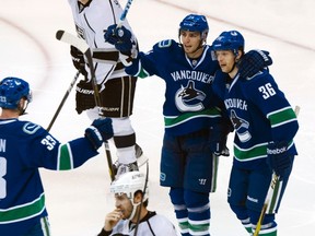 Vancouver Canucks Jannik Hansen, right, is congratulated by teammates Alex Burrows, centre, and Henrik Sedin after scoring on Los Angeles Kings during Game 2 of their NHL Western Conference quarter-final hockey playoff in Vancouver, British Columbia April 13, 2012. (REUTERS/Andy Clark)