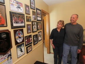 Trish and Tom Zajac check out their family wall of fame. They have four sons playing a high level of hockey. (CHRIS PROCAYLO/Winnipeg Sun)