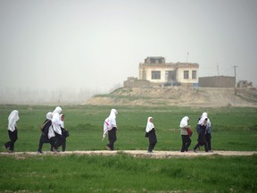 Afghan girls walk home from school near the DHQ (Char Dara District Police Headquarter) in the province of Kunduz on March 29, 2012. (AFP FILE PHOTO / JOHANNES EISELE)
