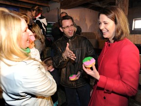 Wildrose leader Danielle Smith, right, has a doughnut and chats with with Bruce McAllister, the Wildrose candidate in the new riding of Chestermere – Rocky View, centre, and his wife Lisa after speaking to the the media at Keith Dugdale's family farm east of Calgary on April 18,2012 (Stuart Dryden/QMI Agency)