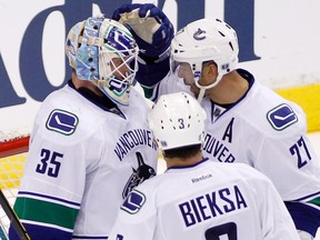 Canucks goaltender Cory Schneider is congratulated by teammates Manny Malhotra and Kevin Bieksa after defeating the Kings in Game 4 of their NHL Western Conference quarterfinal series at the Staples Center in Los Angeles, Calif.,  April 18, 2012. (DANNY MOLOSHOK/Reuters)