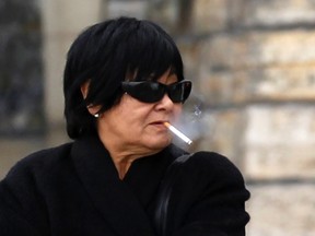 Former international cooperation minister Bev Oda smokes behind Centre Block on Parliament Hill in Ottawa February 16, 2011. (REUTERS/Chris Wattie)