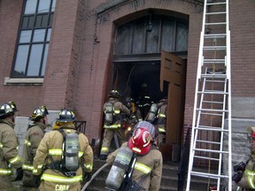 Ottawa firefighters work to douse hot spots after a fire Tuesday morning in the front area of the Parkdale United Church at Gladstone and Parkdale avenues. (Ottawa Fire Service submitted image)