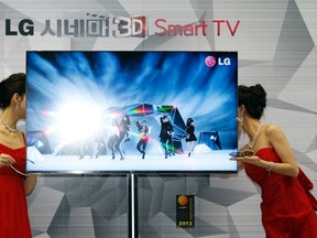 Promoters talk behind a LG CINEMA 3D Smart TV during an event to launch the LG Electronics' new television in Seoul in this January 19, 2012 file photo. (REUTERS/Kim Hong-Ji/Files)