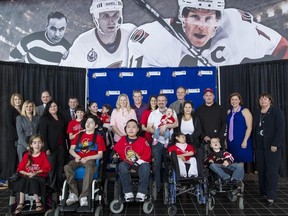 Ottawa Senator Chris Neil and his wife Caitlin pose with corporate sponsors and the Roger's House Dream Team following a press conference at Scotiabank Place. (Errol McGihon/Ottawa Sun)