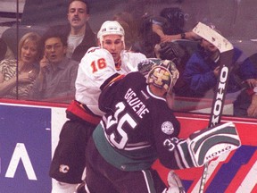 Craig Berube, pictured playing playing for the Calgary Flames, collides with then Anaheim Ducks goaltender Jean-Sebastien Giguere in this Dec. 8, 2001 file photo in Calgary. (QMI Agency files)
