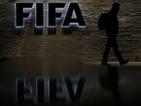 File photo of a silhouetted man walking past the main entrance of FIFA headquarters, the Home of FIFA, in Zurich October 20, 2010. (REUTERS/Christian Hartmann/Files)