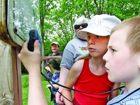 With their grandmother Janet looking on, Trenton and Kassandra McLellan carefully study a handheld GPS unit as they look for hidden treasure during a geocaching demonstration at Wildwood Conservation Area just outside of St. Marys.
MIKE BEITZ/ QMI AGENCY
