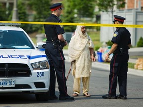 A woman talks with a Peel police officer guarding the Brampton home where 37-year-old Lakhivir Dhaliwal was killed. (ERNEST DOROSZUK, Toronto Sun)