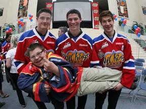 Oil Kings players, from left, Travis Ewanyk, Tristan Jarry and Mason Geertsen hoist superfan Douglas Gaunt for the camera. (photo by Perry Mah/ Edmonton Sun)