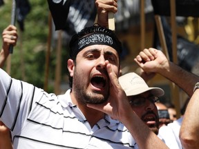 Call to arms: A Lebanese Sunni Muslim Islamist shouts slogans during a protest against what protesters say was the killing of at least 108 people in the Syrian town of Houla by Syrian President Bashar al-Assad's forces. The Arabic writing on his headscarf reads: "There is no God but Allah, Mohammad is Allah's messenger". (REUTERS/Jamal Saidi).