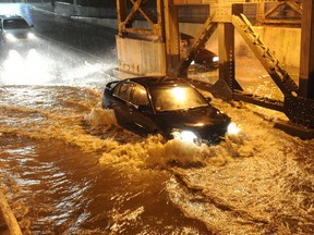Motorists try to go through a flooded underpass in Calgary after a violent thunder shower, June 5, 2012. Heavy lightning and rain caused flooding throughout the city. (Stuart Dryden/QMI Agency)