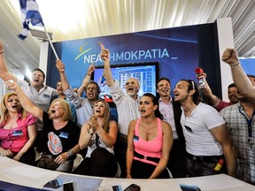 New Democracy (ND) party supporters celebrate as they watch the exit polls at the party's main election campaign kiosk in Athens on June 17, 2012.   AFP PHOTO / MICHALIS KARAGIANNIS